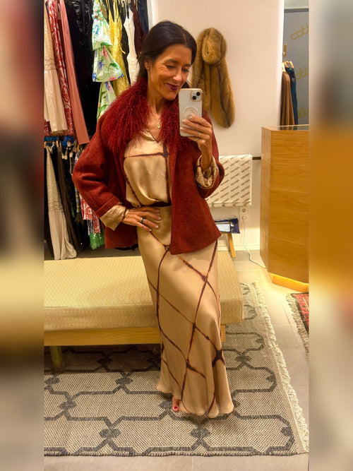 Conjunto beige con cuadros en tono teja compuesto por: falda evasé con cinturilla elástica adaptable a todos los cuerpos y su camisa cuello mao.
